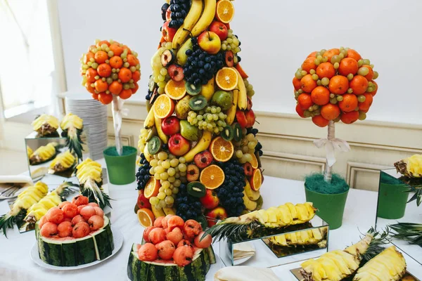 Uma pirâmide de frutas exóticas fica no meio de um buffet — Fotografia de Stock