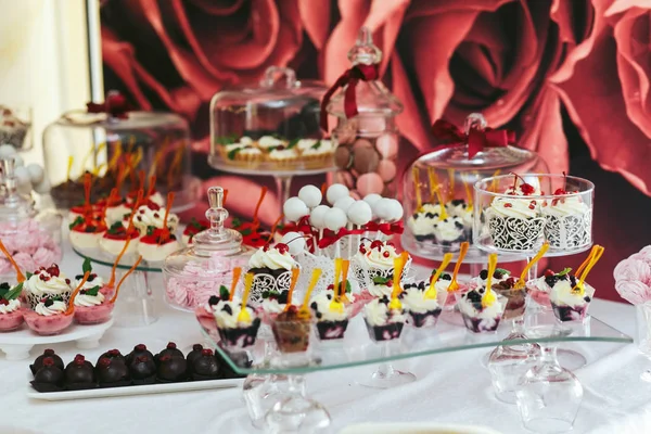 Cupcakes, yogures, chocolates y macarrones se encuentran bajo la cala de cristal — Foto de Stock