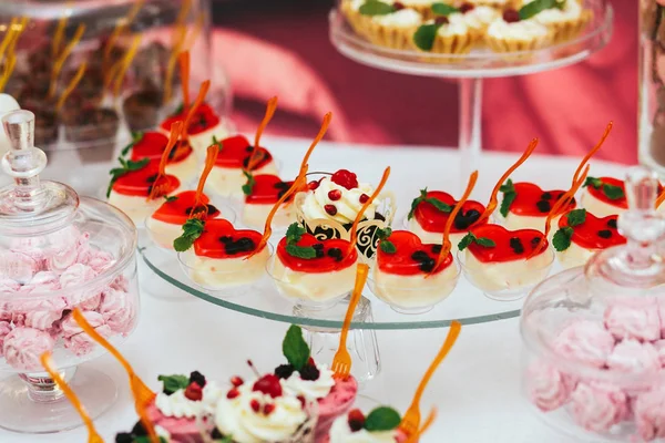 Lilla cheesecakes med röd gelé stå på en buffé — Stockfoto