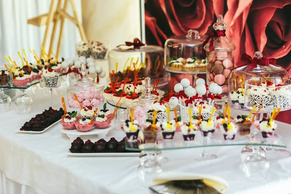 Bir akşam yemeği macaroons vazolar ve yoğurt glase yemekleri standı — Stok fotoğraf