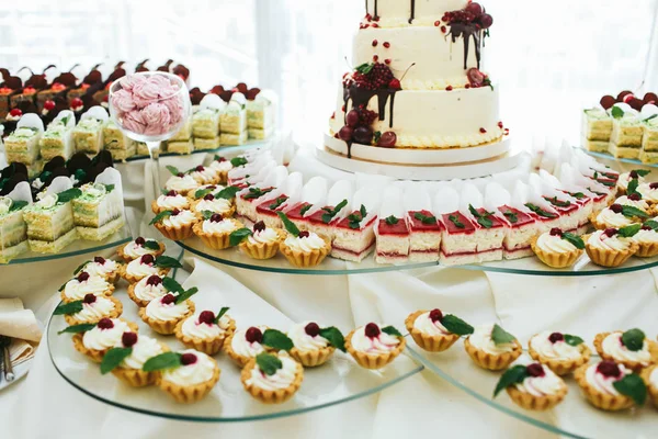 Sweet baskets decorated with mint and berries stand in lines on