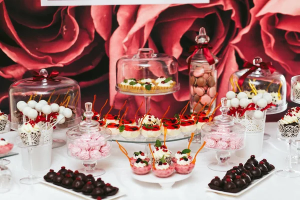 Różowy, biały i brązowy czekoladki stanąć na szklane naczynia na buff — Zdjęcie stockowe
