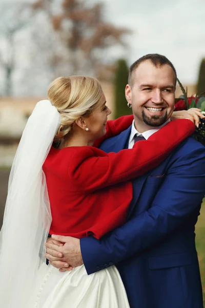 Novia se inclina a un novio abrazando su cuello — Foto de Stock