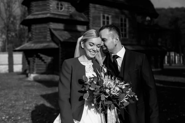 Bride smiles while groom leans to her head — Stock Photo, Image