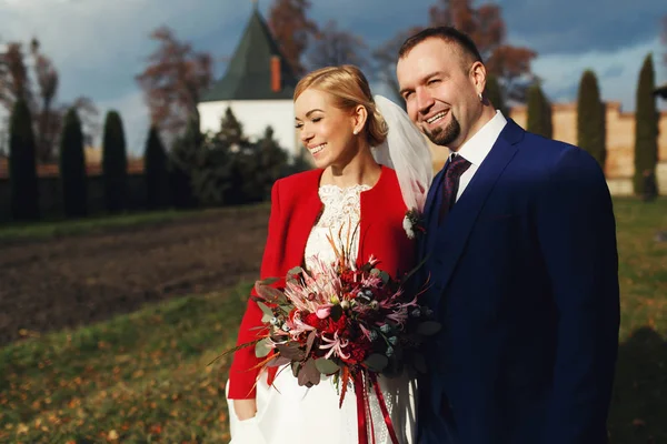 Щаслива весільна пара стоїть у променях сонця — стокове фото