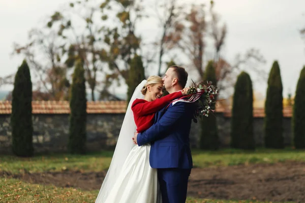 新郎は花嫁の額旧裏庭で彼女を抱いてキスします。 — ストック写真