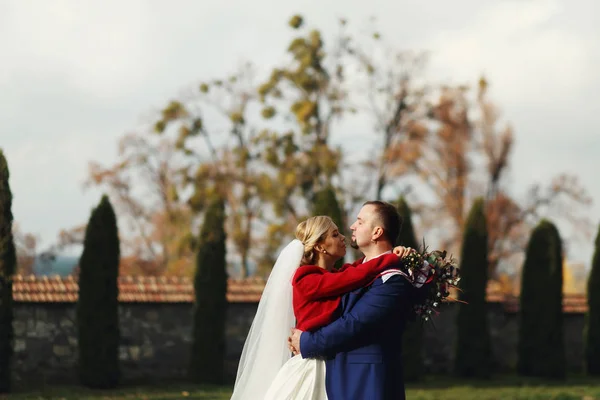 Casamento abraços casal de pé no velho quintal — Fotografia de Stock