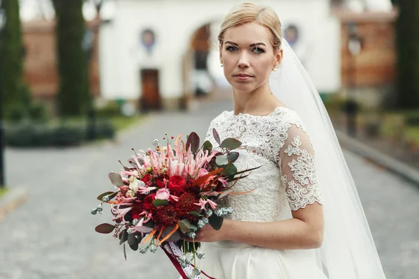 Linda noiva mantém um buquê de casamento outono posando no col — Fotografia de Stock