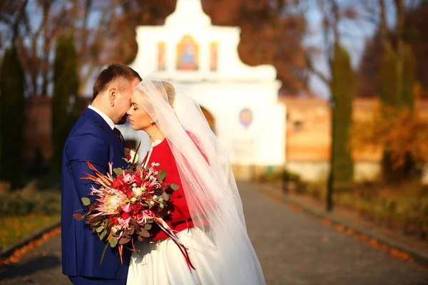 Bruid leunt naar een bruidegom die permanent op de weg naar oude gates — Stockfoto