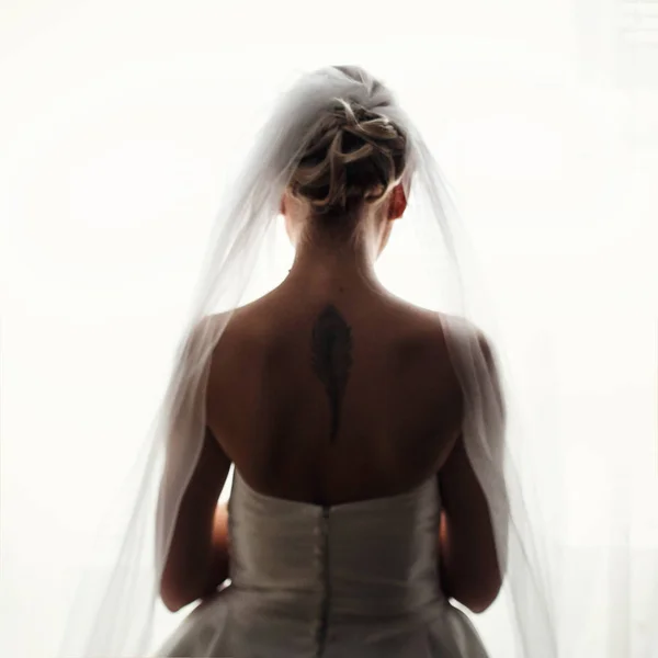 Tattoo of a feather on tender bride's back — Stock Photo, Image