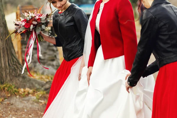 Noiva elegante e damas de honra caminham ao longo da estrada — Fotografia de Stock