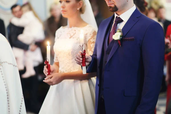 Bruden och brudgummen håller ljus under en engement ceremoni — Stockfoto