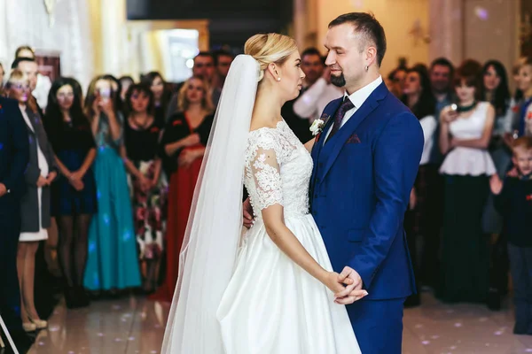 Prachtige bruid kijkt naar een knappe bruidegom tijdens hun eerste dan — Stockfoto
