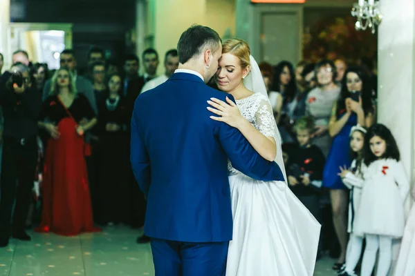 As pessoas admiram um elegante casal de casamentos durante sua primeira dança — Fotografia de Stock