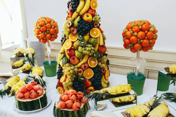 A pyramid of exotic fruits stand in the middle of a buffet Royalty Free Stock Images