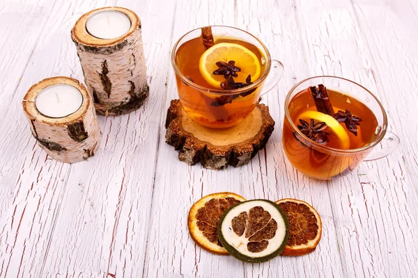 Cup of tea with cinnamon, lemon and other seasonings stands on w — Stock Photo, Image