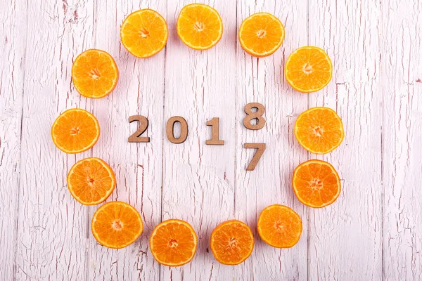 wooden figures and halves of oranges lying on white floor