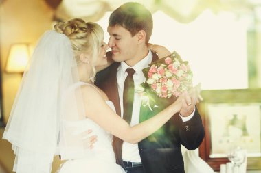 Onun boynuna bir buket ile bir ele sahip bir damat gelin hugs