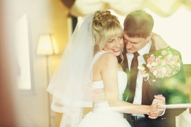 Elini onun n çevresinde tutan bir damat dans gelin gülümsüyor