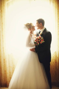 Gelin ve damat g tarafından gizli bir pencere önü gülümseyerek ayağa