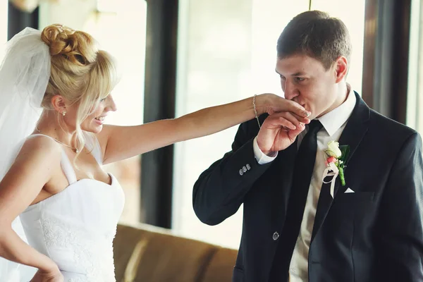 Bräutigam küsst den Arm der Braut, während sie ihm zulächelt — Stockfoto