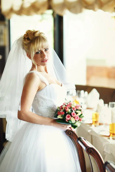 Bonita novia rubia posando detrás de mesas en restaurante — Foto de Stock