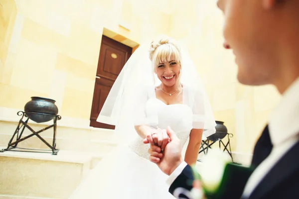 Lefelé megy a lépcsőn, tartó kar vőlegény menyasszony mosolyog — Stock Fotó