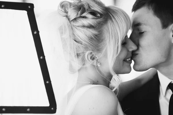 A wedding couple kisses behind a lamp — Stock Photo, Image