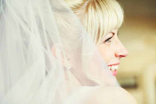 Braut lächelt funkelnd und blickt über ihre Schulter — Stockfoto