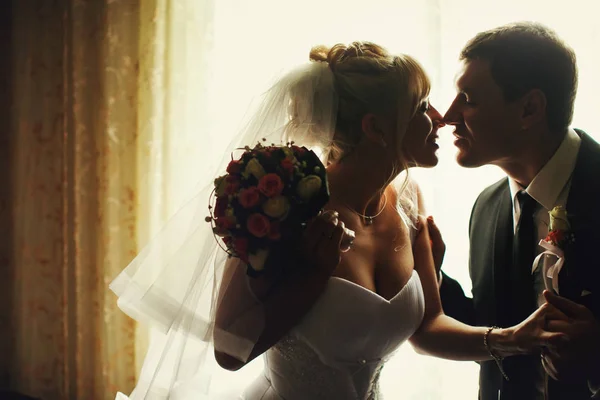 Einen Moment vor einem Kuss zwischen einem dahinter stehenden Hochzeitspaar — Stockfoto