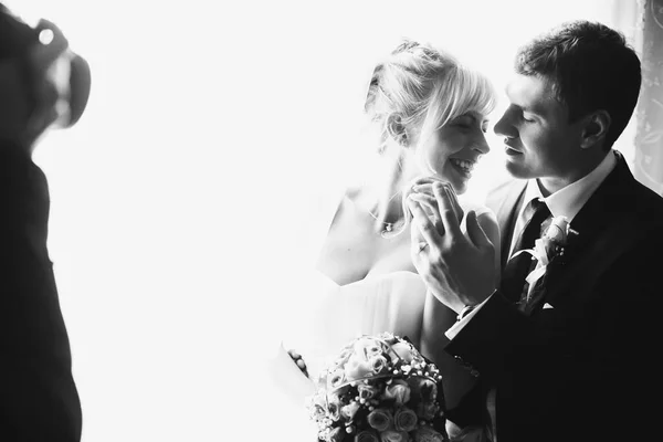 Een fotograaf vangt een prachtig bruidspaar in het front o — Stockfoto