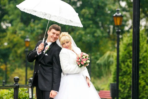 夫妇站立肩并肩在公园里的一把伞下 — 图库照片