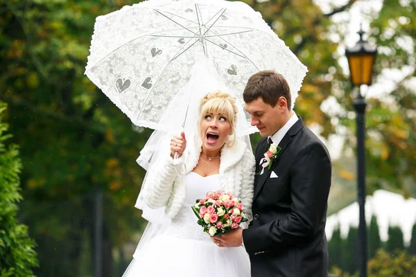 Krzyki Panna Młoda ogląda welon podpięty na parasol — Zdjęcie stockowe