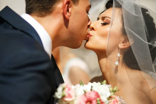A noiva e o noivo se beijando na rua — Fotografia de Stock