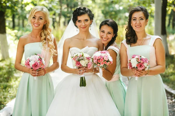 Die charmante Braut und Brautjungfern mit Blumensträußen — Stockfoto