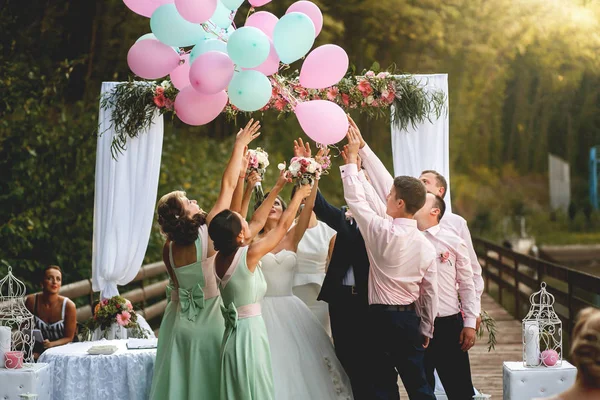 Pareja con invitados pone globos en el cielo — Foto de Stock