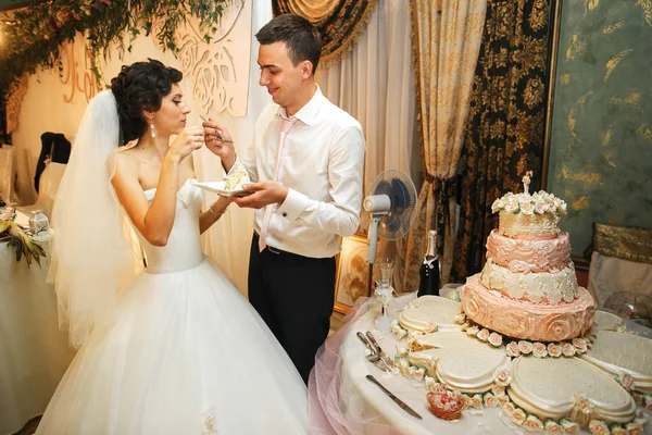 Brudar eatting en bröllopstårta — Stockfoto