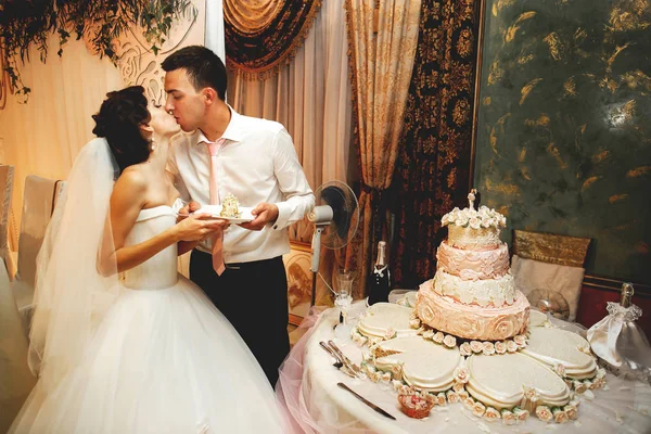 Pár csók közelében esküvői torta — Stock Fotó