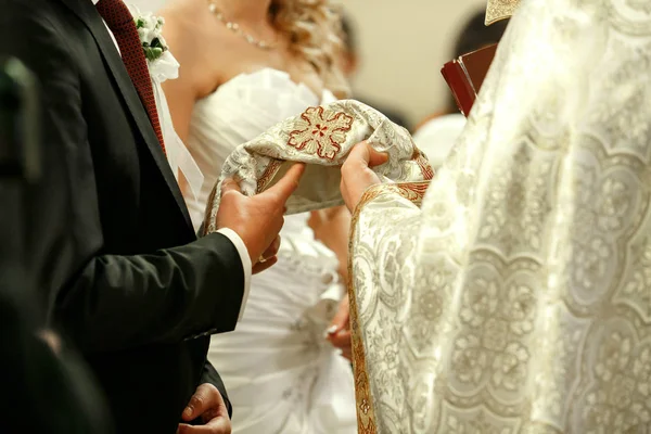 Brudgummen och bruden står bakom en präst under en förlovning cerem — Stockfoto