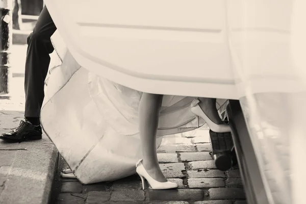 Een close-up van van bruid benen terwijl ze in de auto stappen — Stockfoto