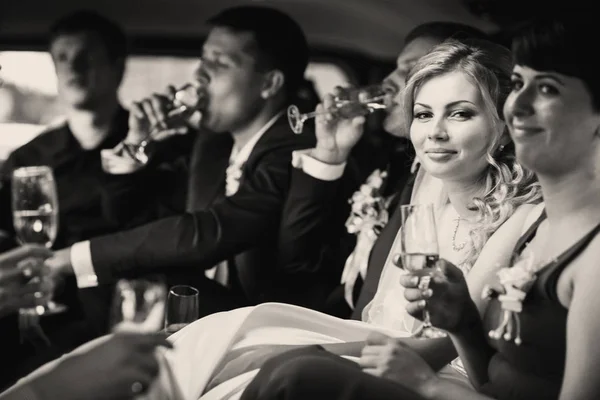Μόλις παντρεμένο ζευγάρι και οι φίλοι τους πίνουν σαμπάνια σε το lim — Φωτογραφία Αρχείου