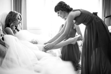 Nedime bir jartiyer gelinin bacak koyar. 