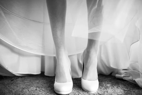 Tipis halus kaki pengantin dalam sepatu putih di bawah gaun pengantin — Stok Foto