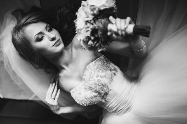 İhale gelin kanepede aittir ve onu buket görünüyor 