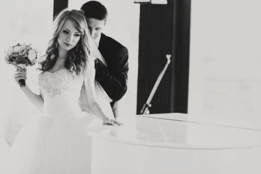 Gelin Damat ondan hugs iken bir piyano düşünceli standları