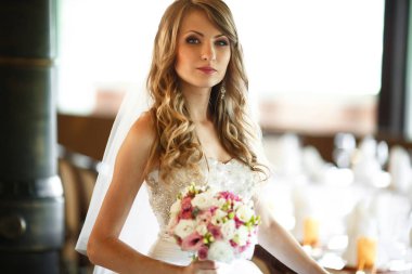 Boş bir tablo arkasında muhteşem duran gelin görünüyor 