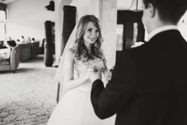 Damat şefkatle kollarını tutar ise gelin gülümsüyor 