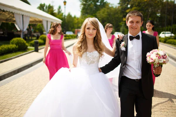Novio sostiene novia cintura tiernamente caminando alrededor del parque — Foto de Stock