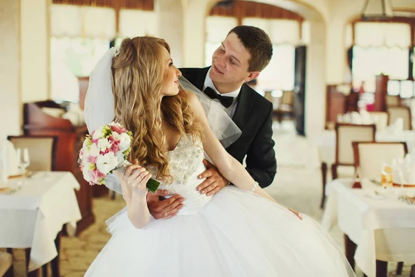 Жених смотрит невесте в глаза, обнимая ее сзади в пустой — стоковое фото