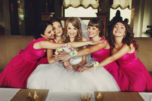 Pembe elbiseler nedime kanepede oturan bir gelin sarılmak 